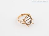 an image of a gold ring on a white surface with a black and white stripe