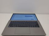 laptop computer sitting on a white surface with a blue screen