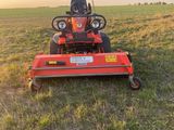 a red lawn mower sitting on top of a lush green field