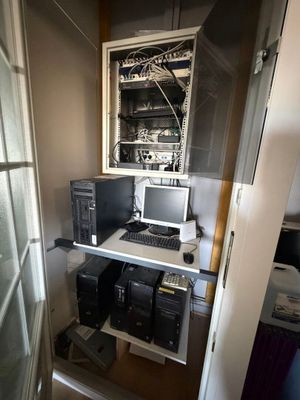 un ordinateur posé sur un bureau dans un coin de la pièce
