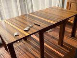 a wooden table and chairs in front of a window