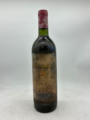 une vieille bouteille de vin posée sur une surface blanche