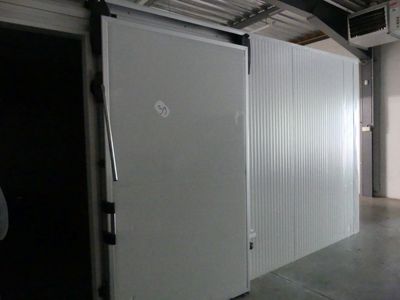 une photo d'un garage dans lequel se trouve un réfrigérateur