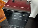 a small black oven sitting on the floor next to a table