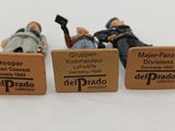 three miniature figurines of people sitting on a bench