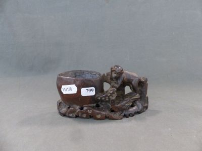 une petite figurine représentant un singe et un bol posés sur une table