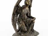an image of a statue of an angel sitting on a rock
