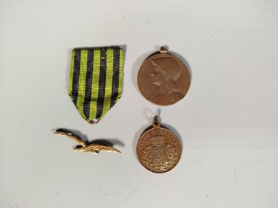 deux médailles et une médaille sont posées sur une surface blanche