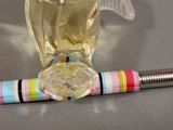 a bottle of perfume next to a pen on a table