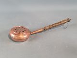 a small metal object with a wooden handle sitting on a table