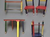 four different colored desks with pencils on them on a gray surface