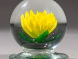 une boule de verre contenant une fleur jaune