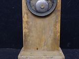 a wooden clock that is on display on a black background