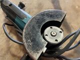 someone is using a circular tool to cut a piece of metal