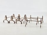 three silver figurines of people sitting on a bench
