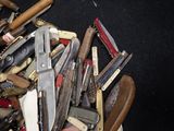 many different types of knives in a pile on the floor