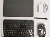 a black keyboard and a charger on a white table