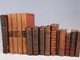 several old books stacked on top of each other on a white surface