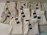 plusieurs paires de pantalons kaki pour homme, avec leurs étiquettes de prix encore attachées