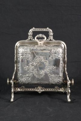 a silver plated box with a handle and handle on a stand