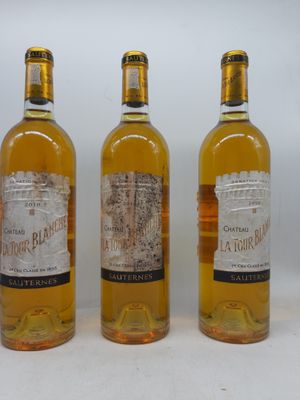 trois bouteilles de vin posées les unes à côté des autres sur une surface blanche