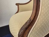 an old fashioned chair with a blue carpet and a white wall