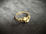 a close up of a gold ring with pearls on it