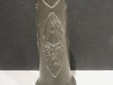 un vase noir orné d'un motif, posé sur une table