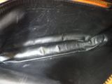 a close up of a black purse with a yellow handle