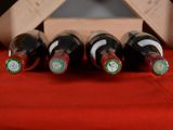 several bottles of wine are lined up on a red cloth