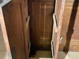 a wooden cabinet with a door open on a tiled floor