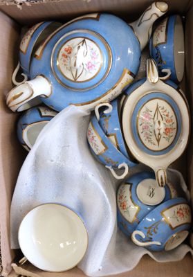 a box full of blue and white tea cups and saucers