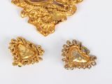 three pieces of gold jewelry on a white surface