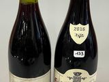 two bottles of wine sitting next to each other on a table