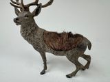 a small statue of a stag standing on a white surface