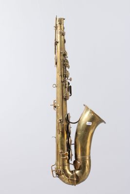 an old brass saxophone sitting on top of a wooden stand