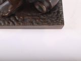 a bronze statue of a bear sitting on a rock