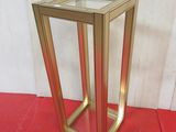 a gold metal frame with a glass top on a red floor