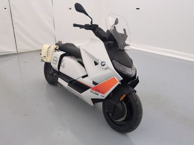 une moto garée dans une pièce aux murs blancs et au sol blanc