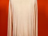 a white sweater on a mannequin stand against a red wall