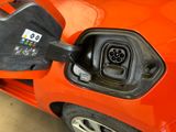 an orange car with a fuel pump attached to it ' s side