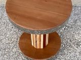 a small table with a wooden top on a sidewalk