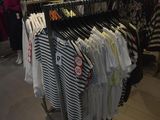 a rack of clothes in a clothing store with clothes on hangers