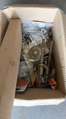 a cardboard box full of screws and nuts on the floor