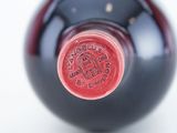 a close up of a bottle of wine on a white surface