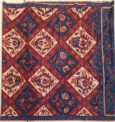 un tapis rouge et bleu orné d'un motif de fleurs et de feuilles