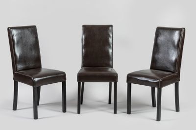 trois fauteuils en cuir marron placés les uns à côté des autres sur une surface blanche