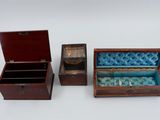 three small wooden boxes are lined up on a white surface