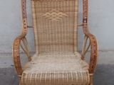 a wicker chair that is sitting in front of a wall