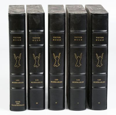 quatre livres noirs sont alignés sur une surface blanche